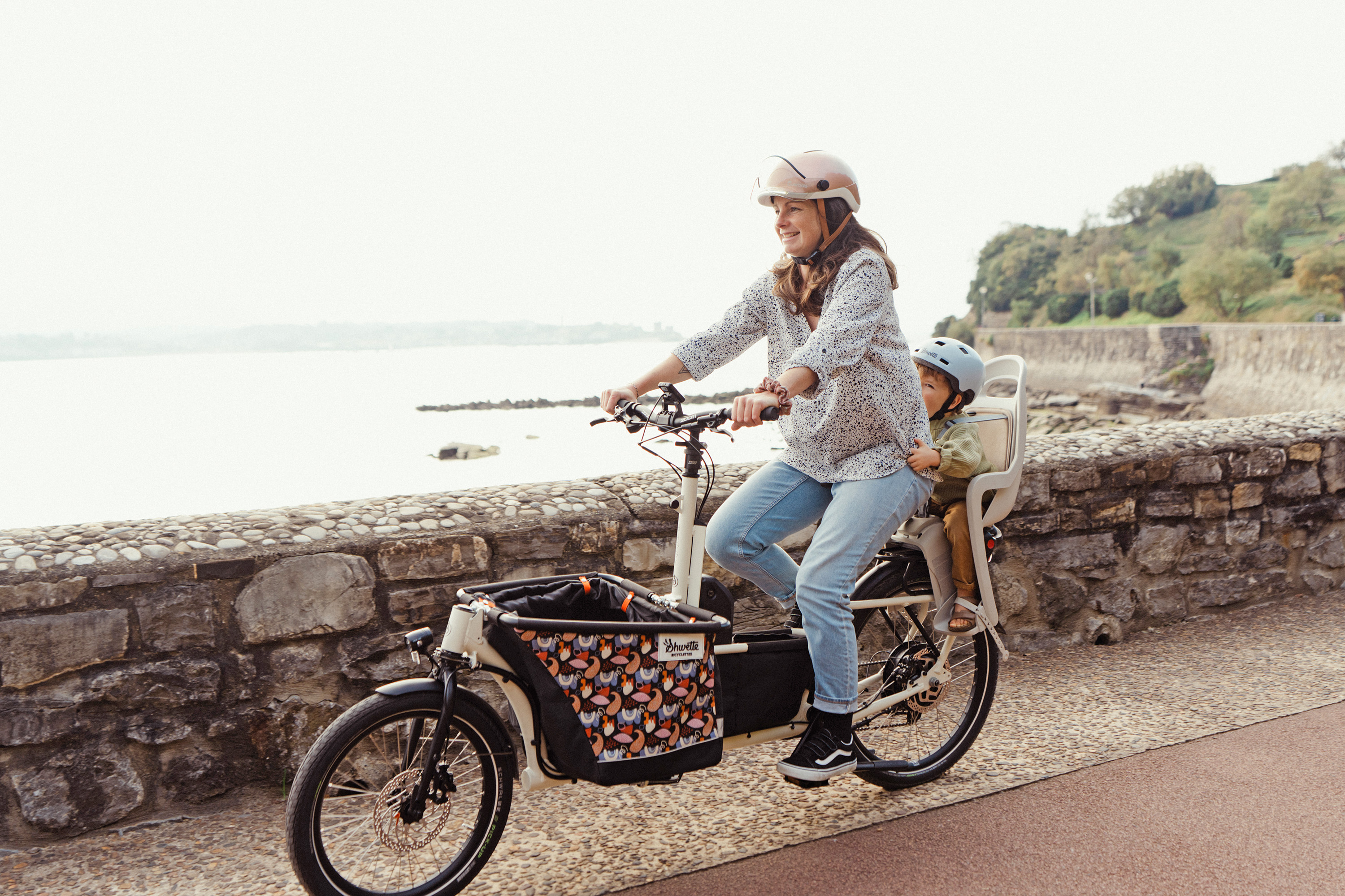 Une Maman sur son vélo Shwette Baggy dont avec son enfant assis sur le siège bébé arrière