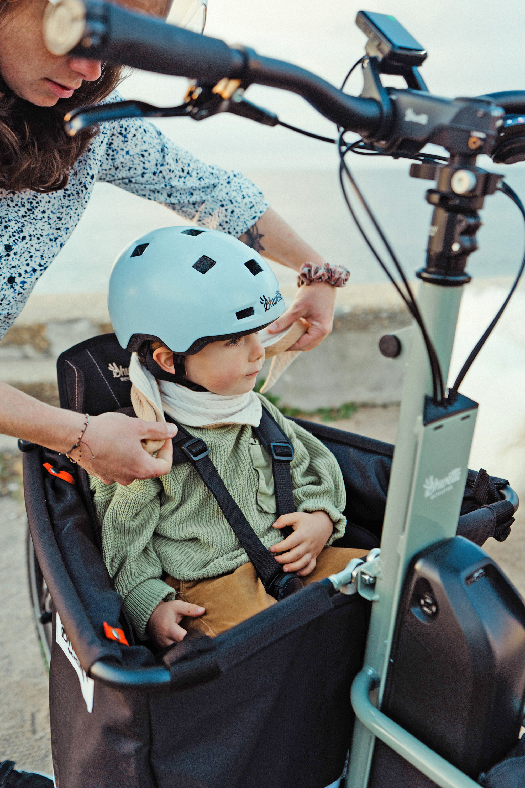 Installation d'un jeune enfant sur le siège enfant placé dans la caisse du vélo Shwette Baggy vendu par Le Cycle Nantais